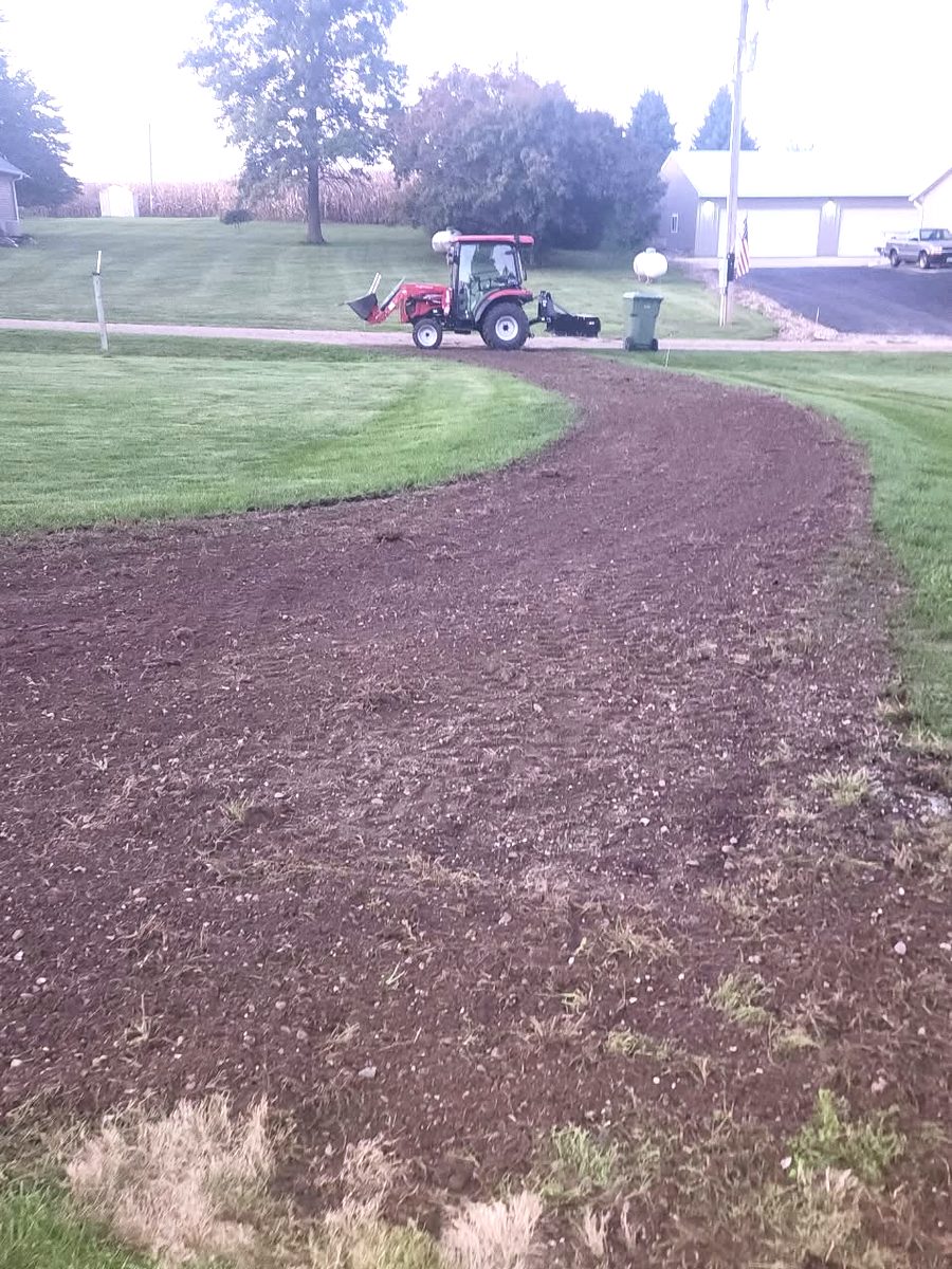 The same drive after QC Tractor Works cleared and graded it, with the tractor in the background